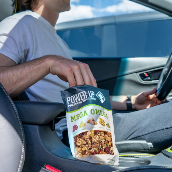 power-up-mega-omega-trail-mix-pdp-image-guy-in-car Man in car eating Power Up Mega Omega Trail Mix