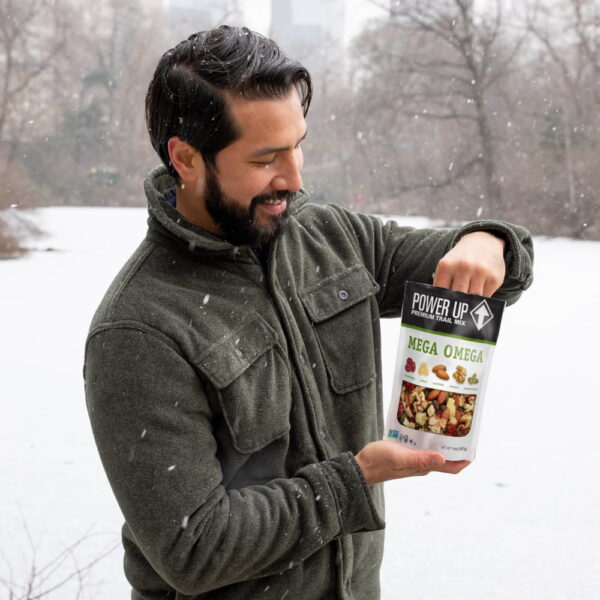 power-up-mega-omega-trail-mix-pdp-image-guy-in-snow Man eating Power Up Mega Omega Trail Mix